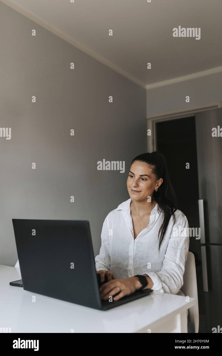 Smiling woman using laptop Stock Photo