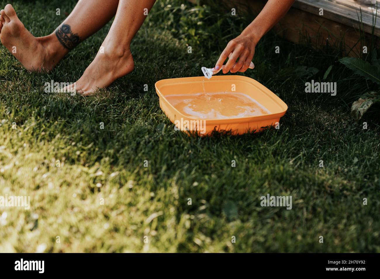 Girl Rinsing Razor Woman's hand cleaning razor Stock Photo - Alamy