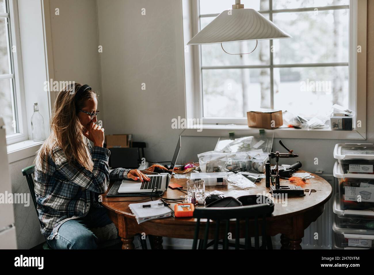 Woman using laptop in kitchen Stock Photo