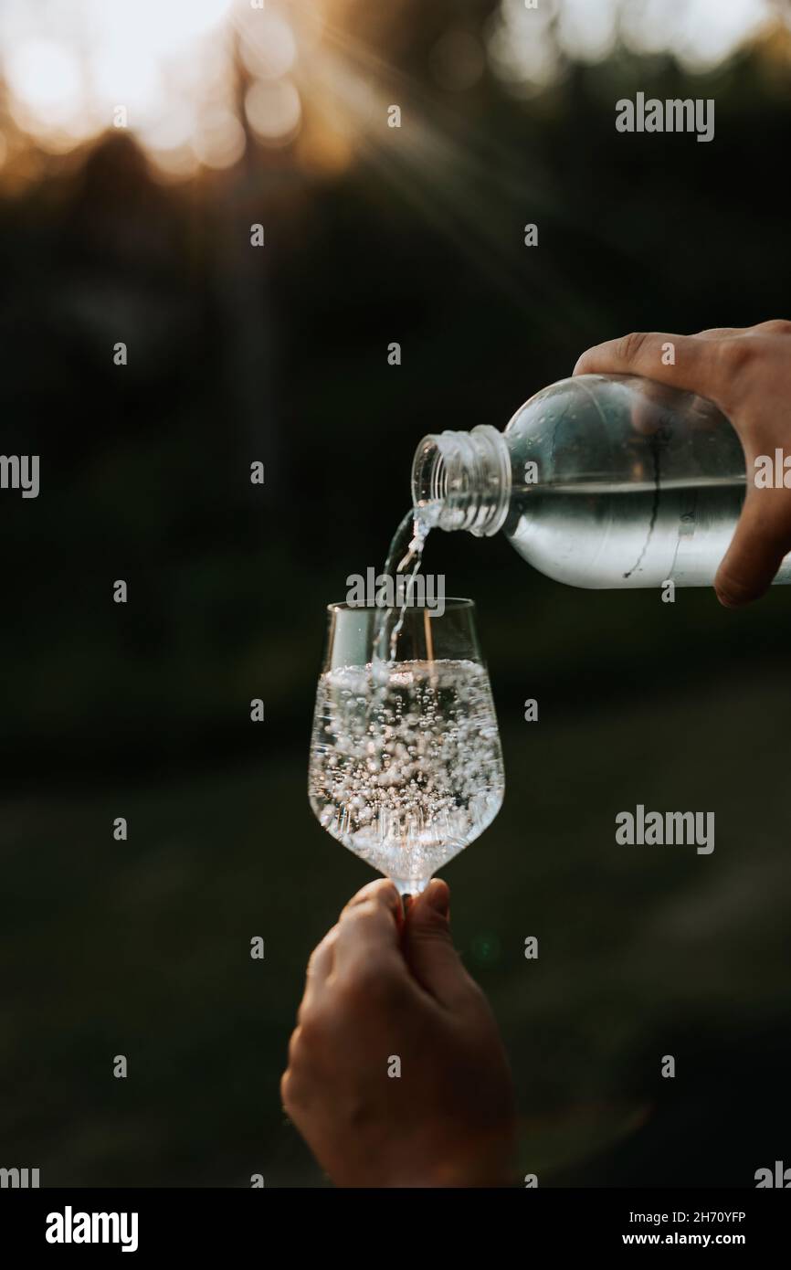 Person pouring water into glass Stock Photo