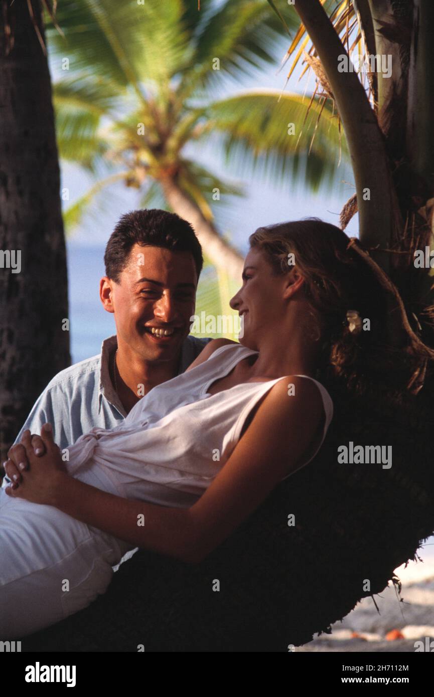 Close up of young couple with coconut palm tree. Maldives. Stock Photo