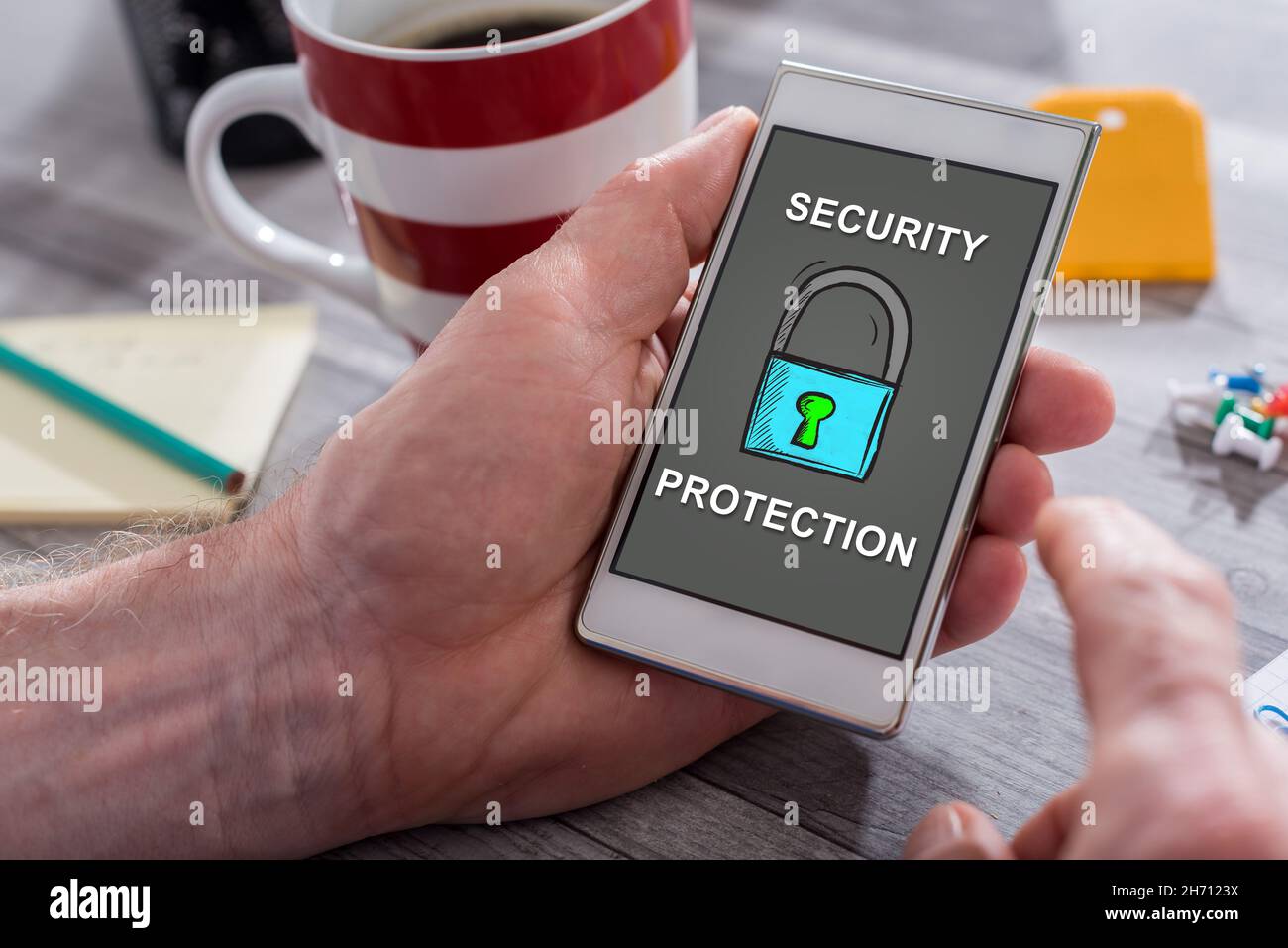 Male hand holding a smartphone with cyber security concept Stock Photo ...