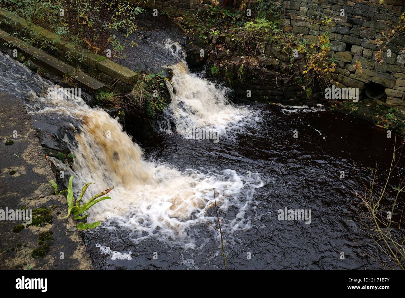 Two small water falls weirs stone banks and centre channel white water Stock Photo