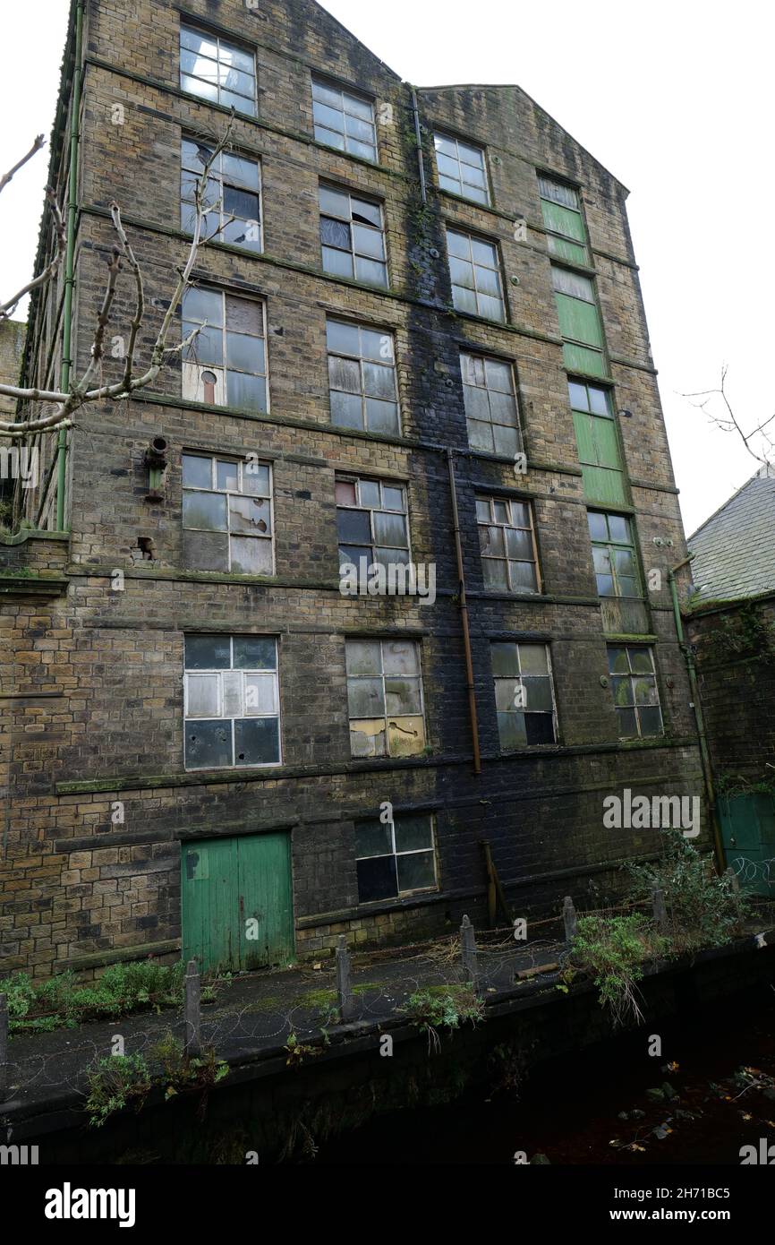 Old abandoned six story stone built factory with broken windows Stock Photo