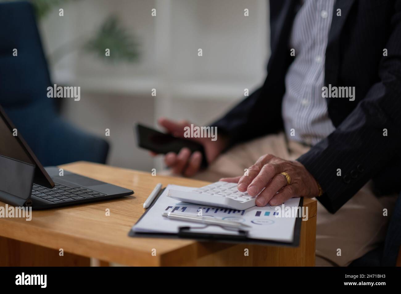 Close up hand of elderly accountant working on desk using calculator for calculate finance report in office. Businessman calculating business balance Stock Photo