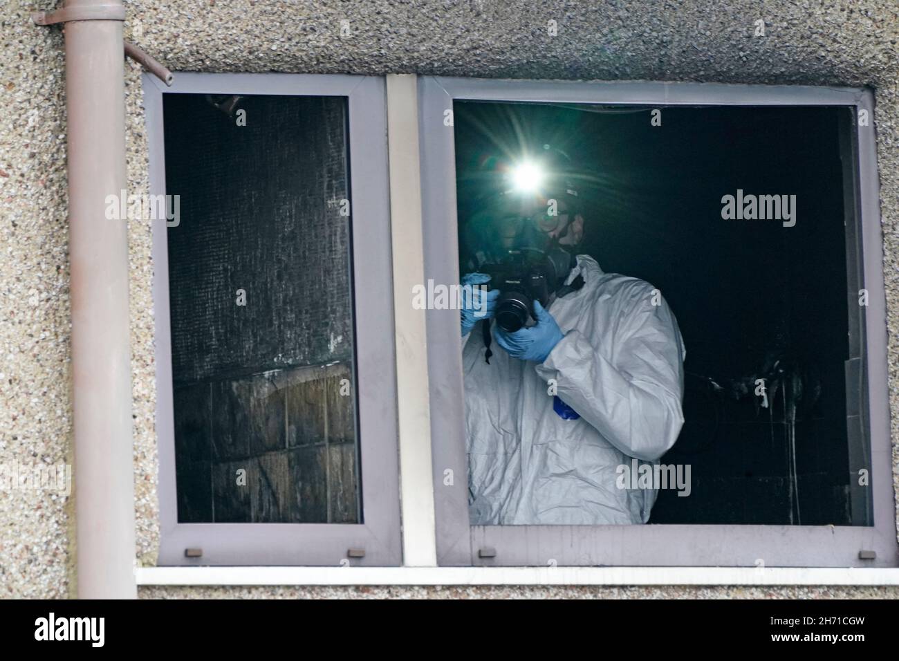 A forensic officer takes pictures inside a house following a fire on