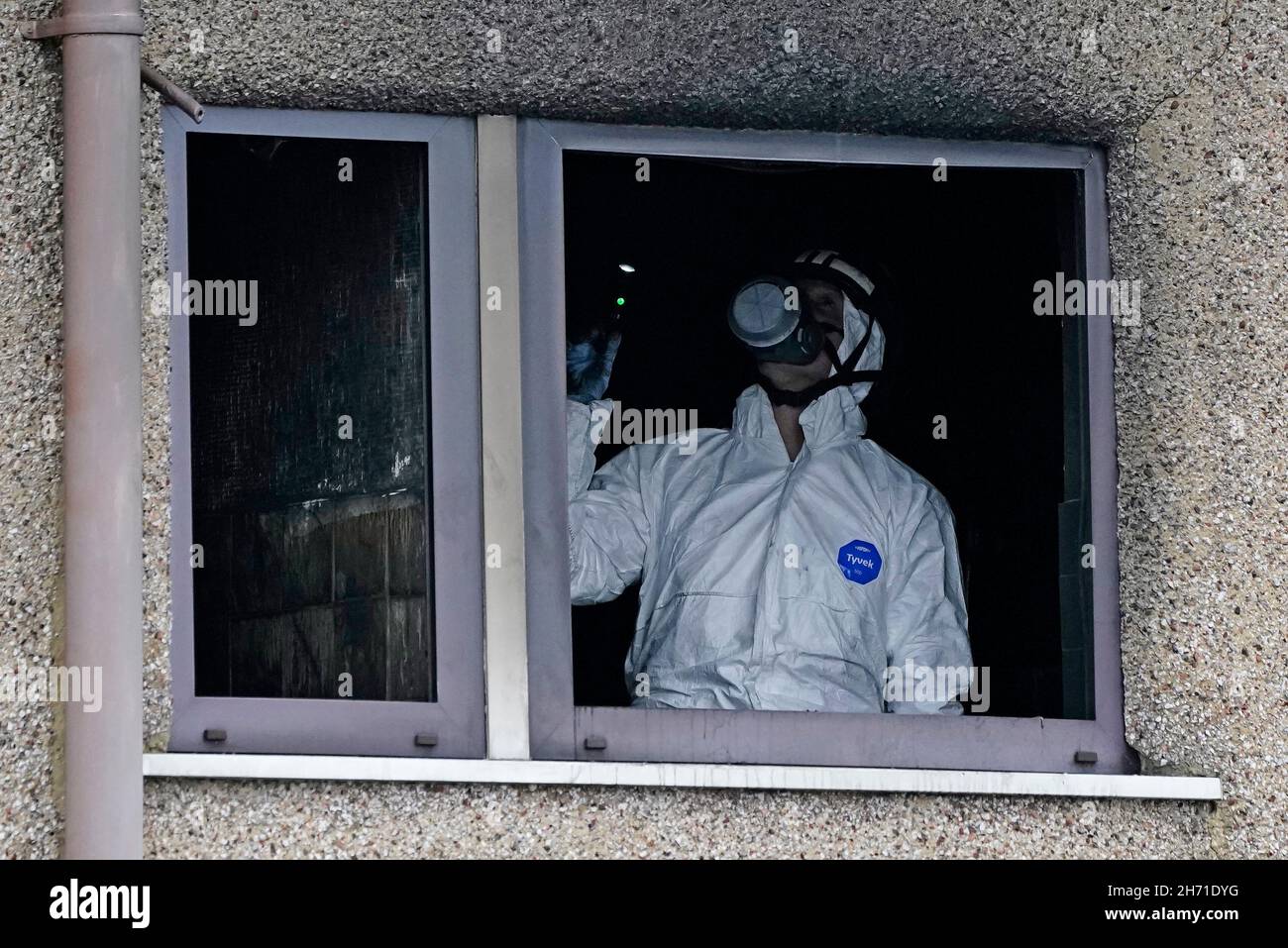 A forensic officer takes pictures inside a house following a fire on