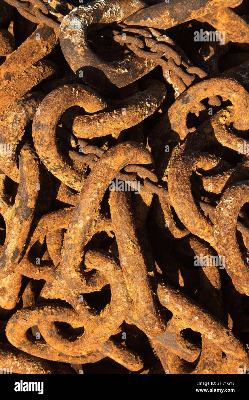 Rusty old anchor chains make an interesting study of colour and texture. Seldom discarded they will be resource to other tasks in the fishing industry Stock Photo