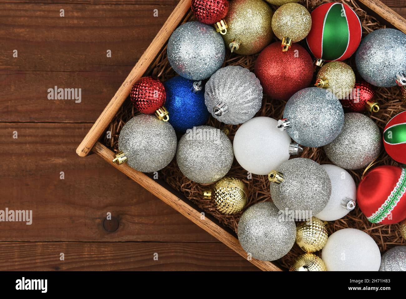 Christmas Flat Lay - Wood Box of Christmas Tree Ornaments on a rustic dark wood surface. Stock Photo