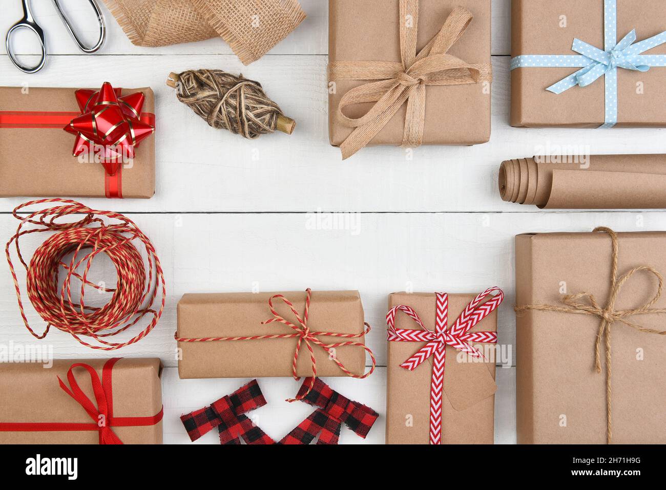 Christmas Flat Lay - Plain brown kraft paper wrapped presents and accessories with middle copy space. Stock Photo