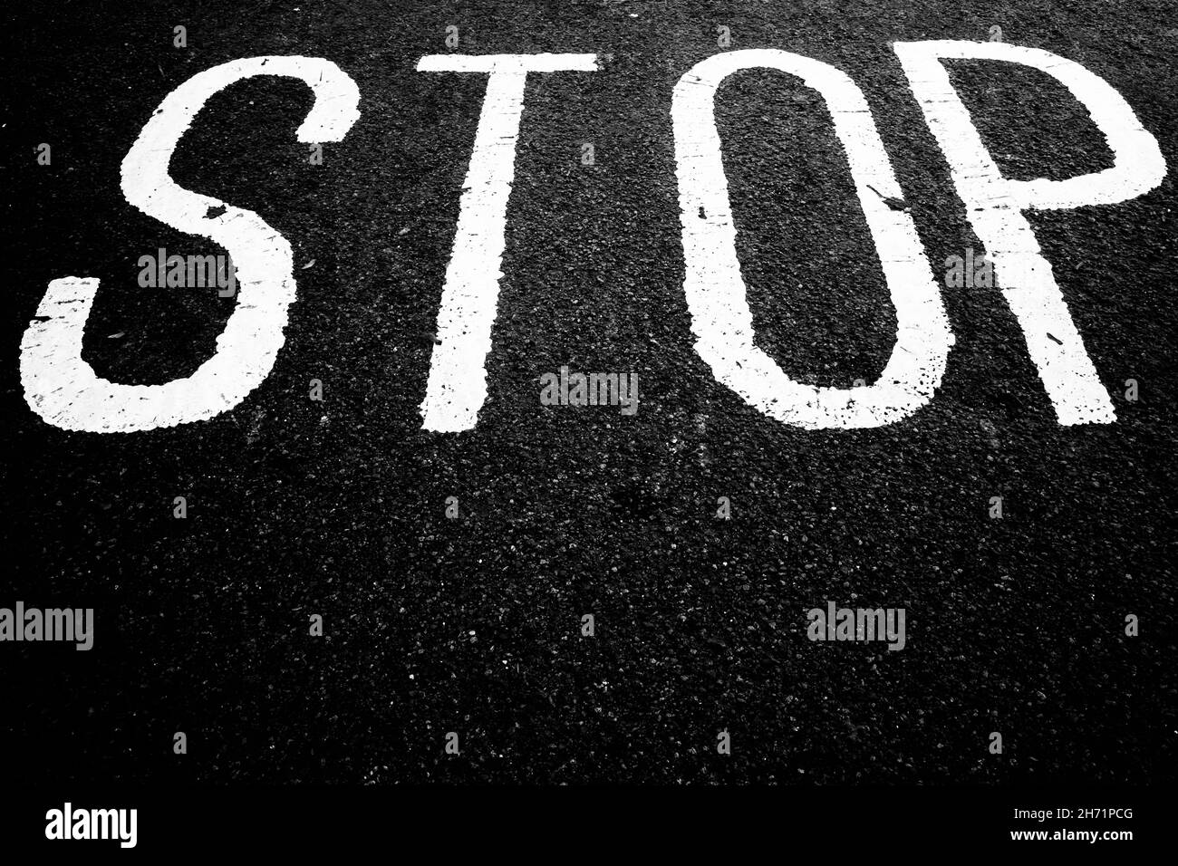 Grayscale shot of stop on asphalt Stock Photo