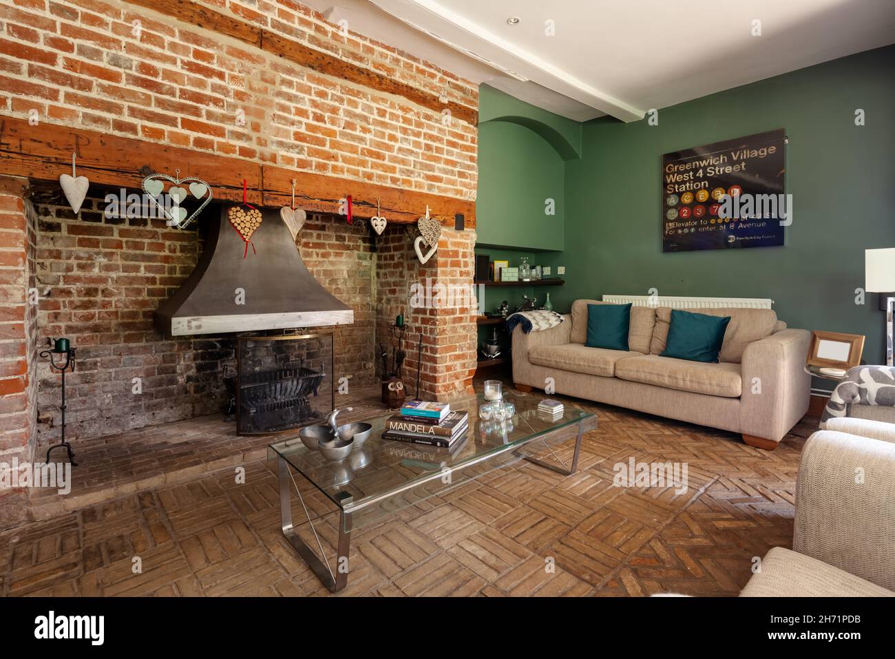 Ashdon, England  - July 25 2019: traditional farmhouse living room inside British home with large exposed brick inglenook fireplace Stock Photo