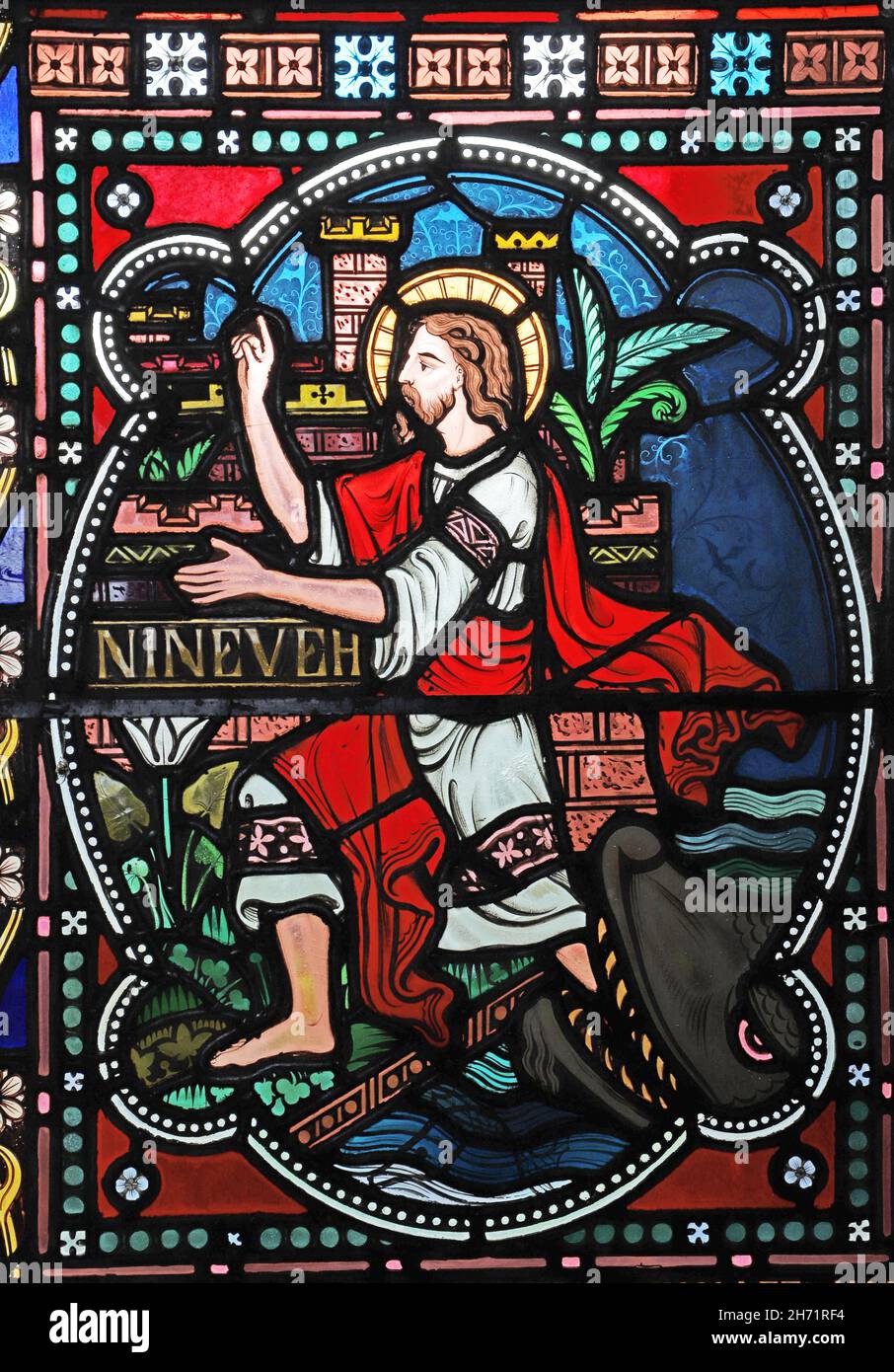 A stained glass window by Frederick Preedy depicting Jonah emerging from the whale, St Peter's Church, Willersey, Gloucestershire. Stock Photo