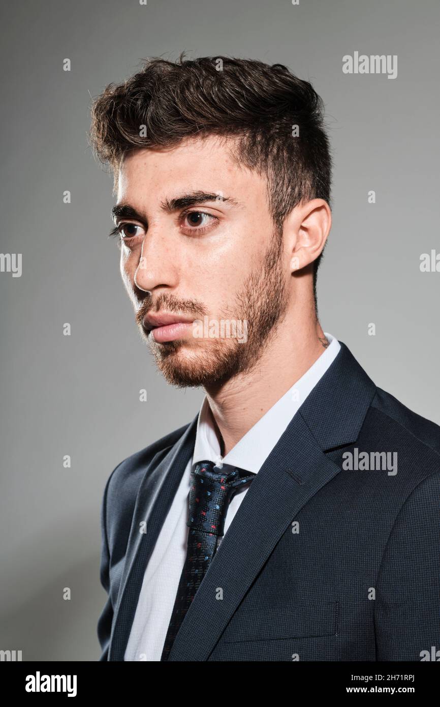 Young man portrait wearing a dark blue suit and a dark blue tie with ...