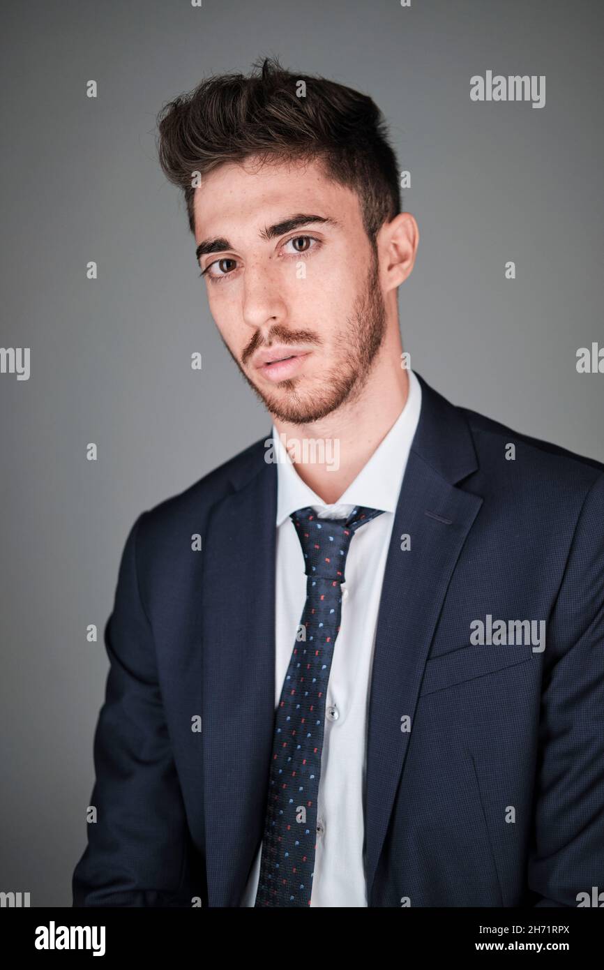 Young man portrait wearing a dark blue suit and a dark blue tie with ...