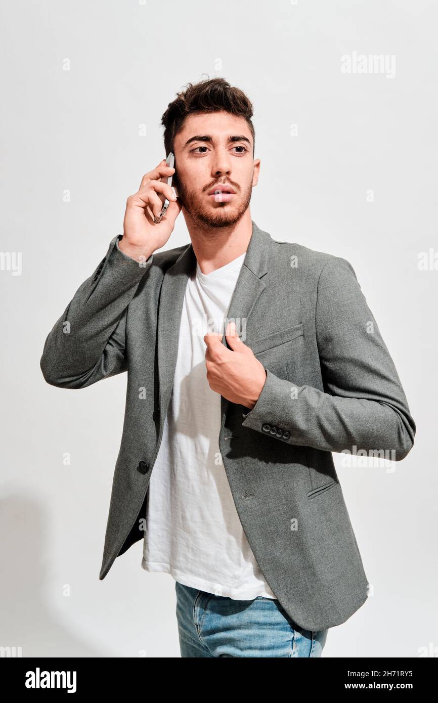Serious young man wearing jeans a white tshirt and a grey blazer