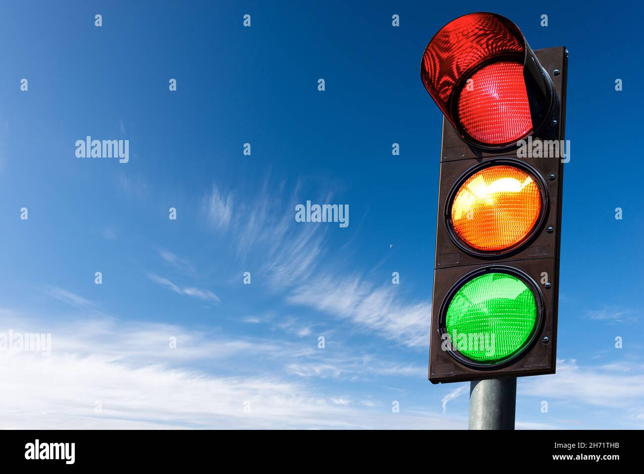 Closeup of a traffic light on a blue sky with clouds and copy space