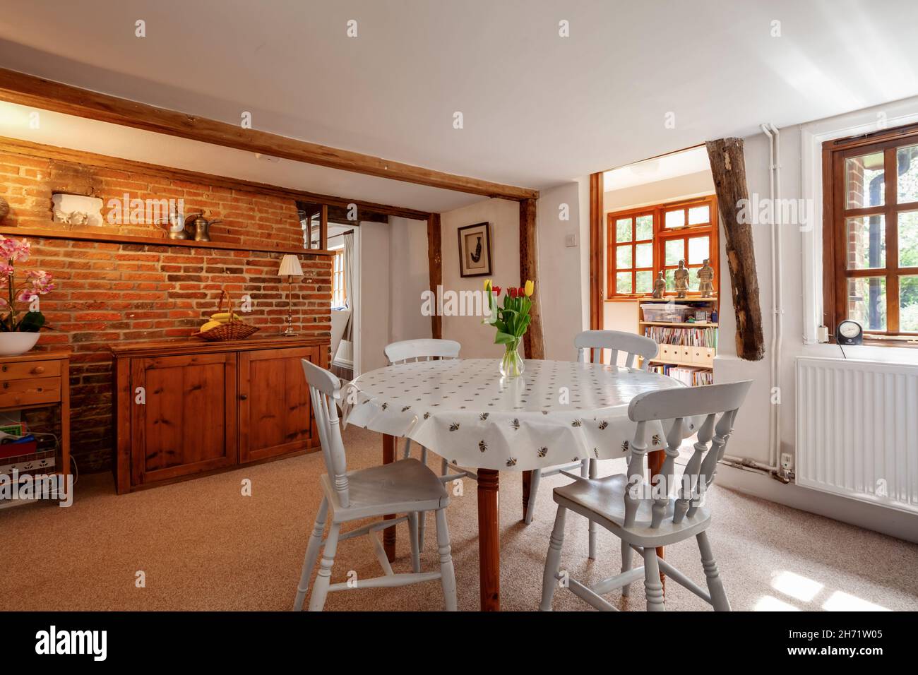 Whepstead, Suffolk, England - June 2 2020: Traditional dining area in home interior with exposed brick wall with small table and chairs Stock Photo