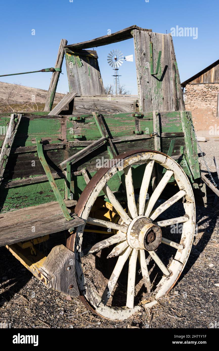 An old broken down ranch chuck wagon with a windbill behind in the