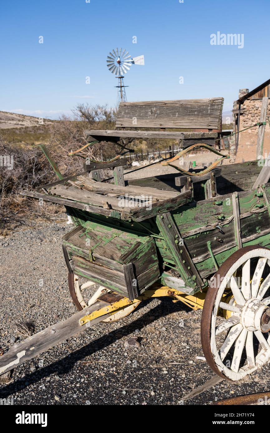 An old broken down ranch wagon with a windbill behind in the ghost town