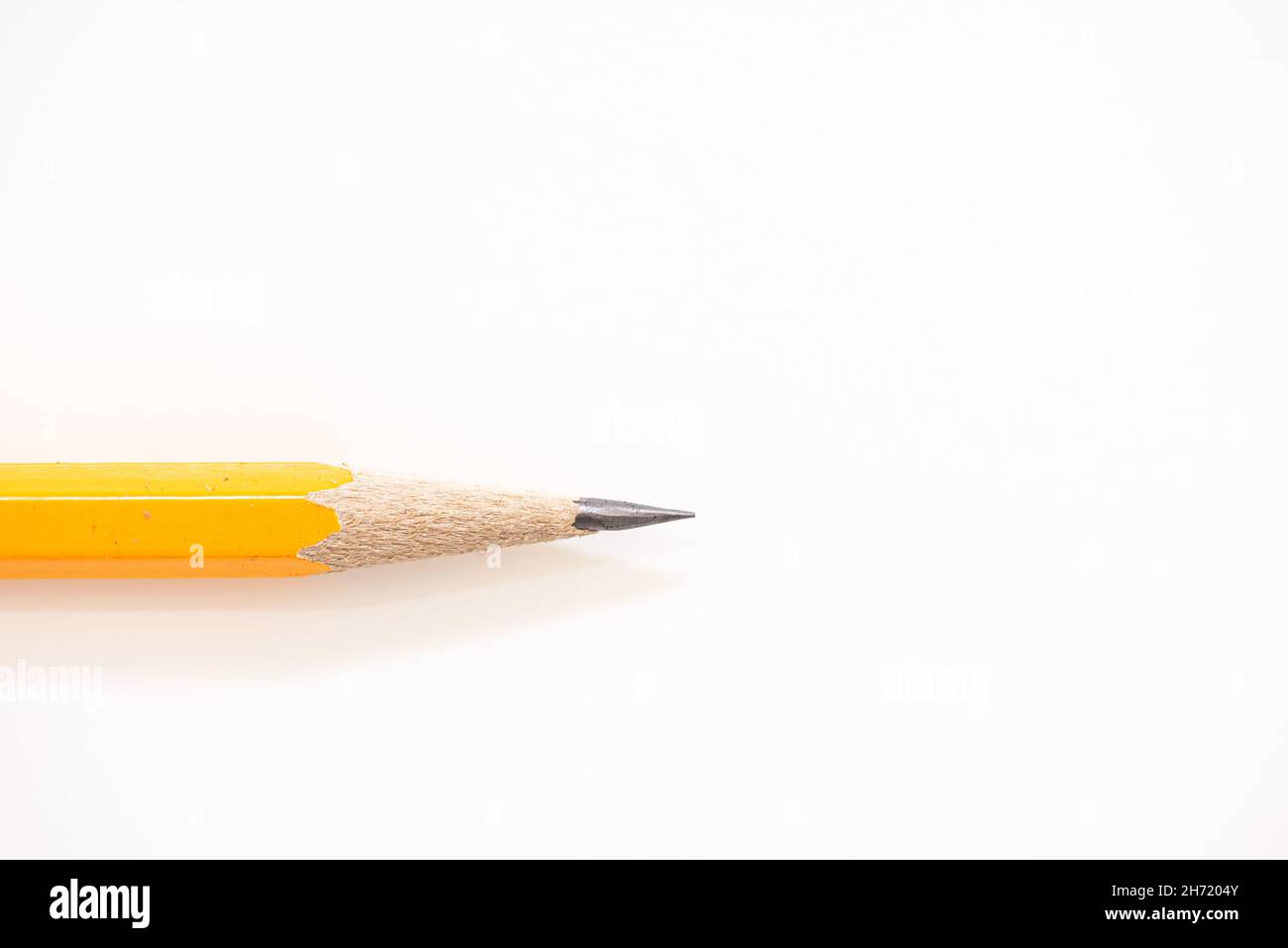 Close up details of sharpened yellow pencil isolated over white background Stock Photo