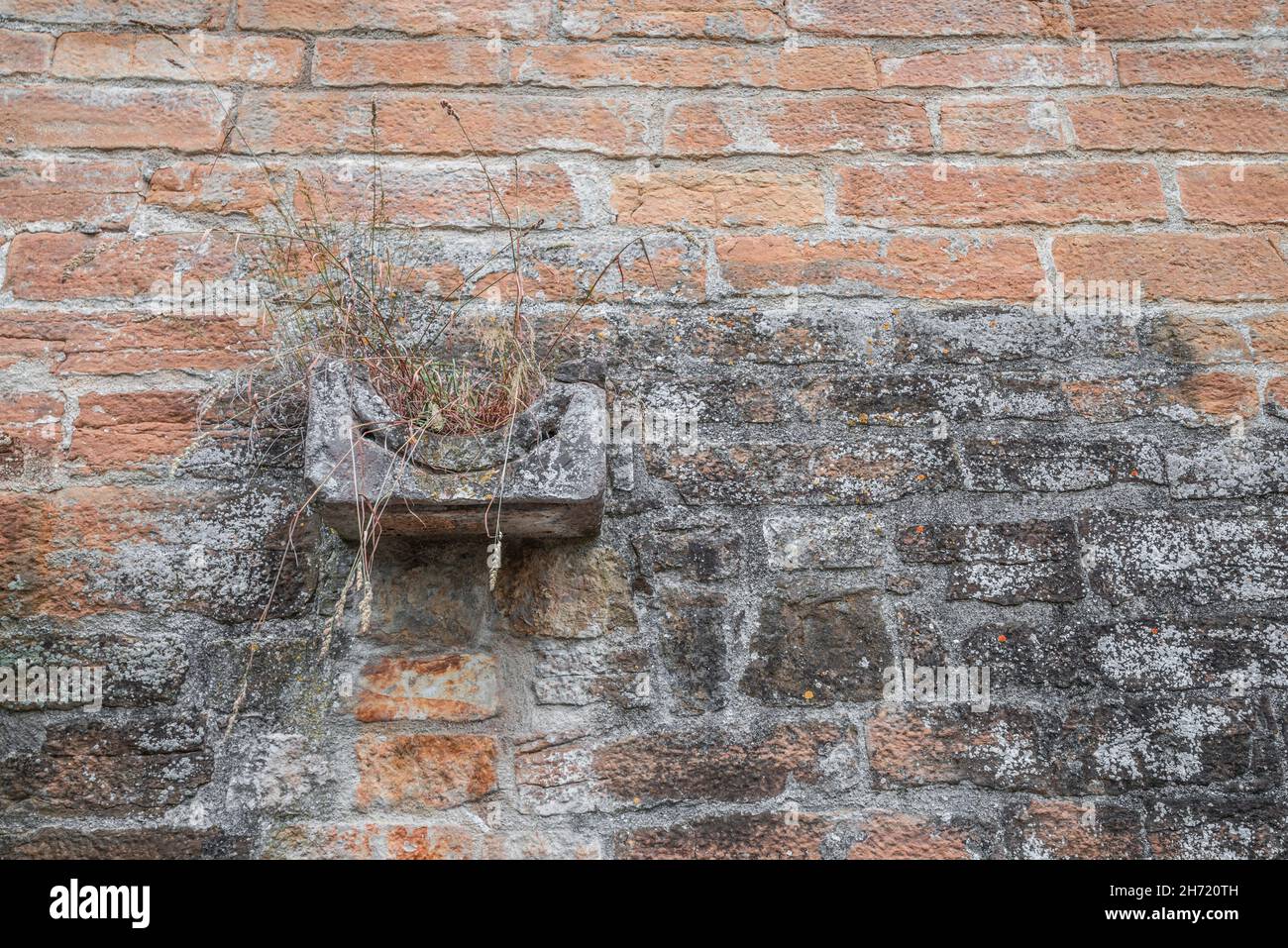 Water gutter stone on an old medieval masonry stone wall stone wall