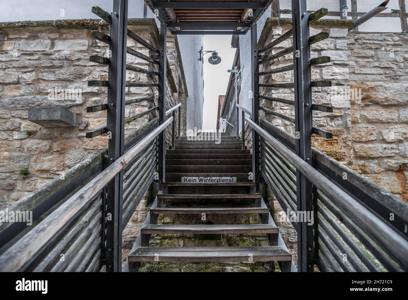 Wooden stairs with railing and wooden steps in a small alley with a ...