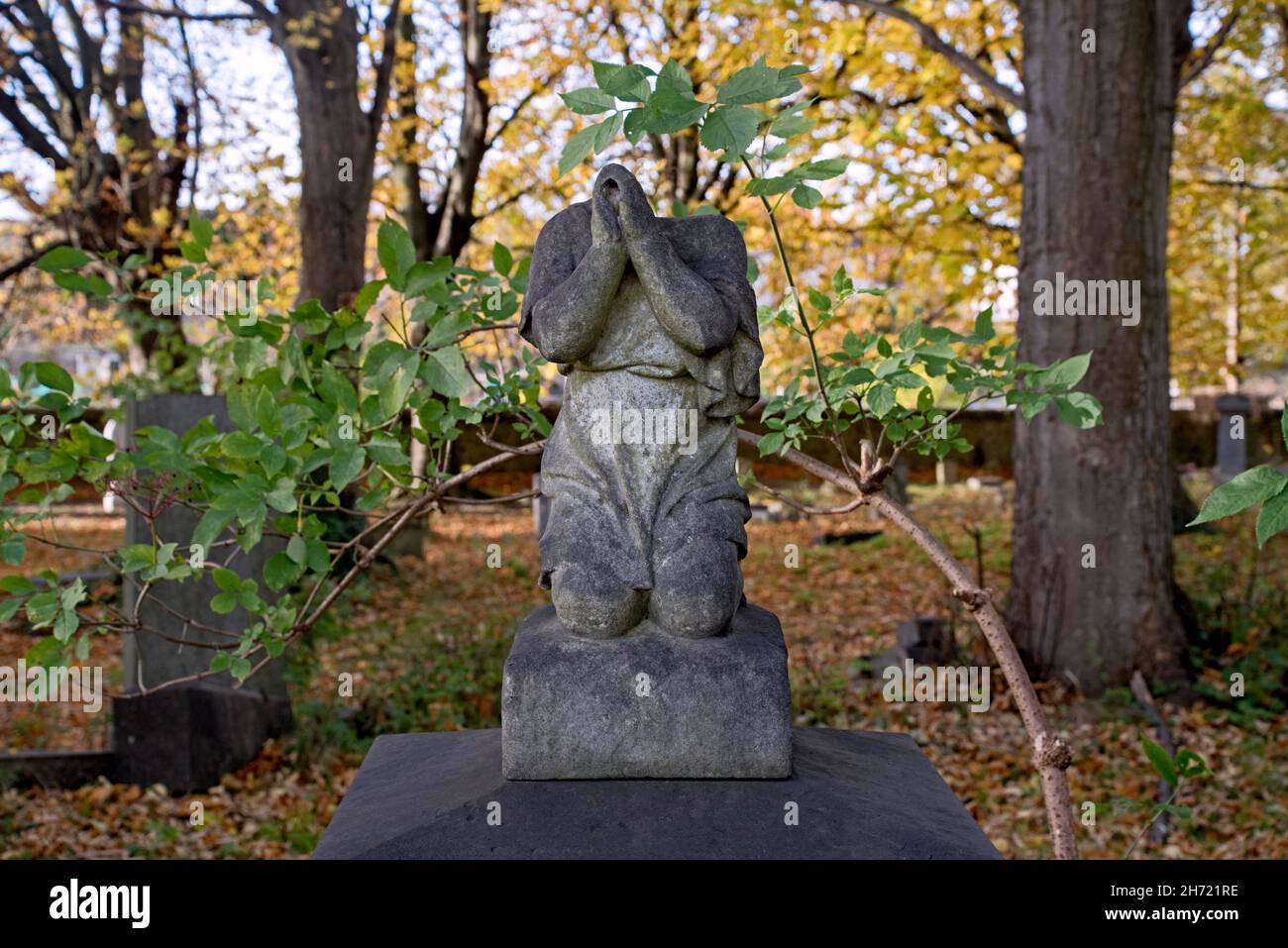 Headless figure kneeling in prayer on a grave in Newington Cemetery, Edinburgh, Scotland, UK. Stock Photo