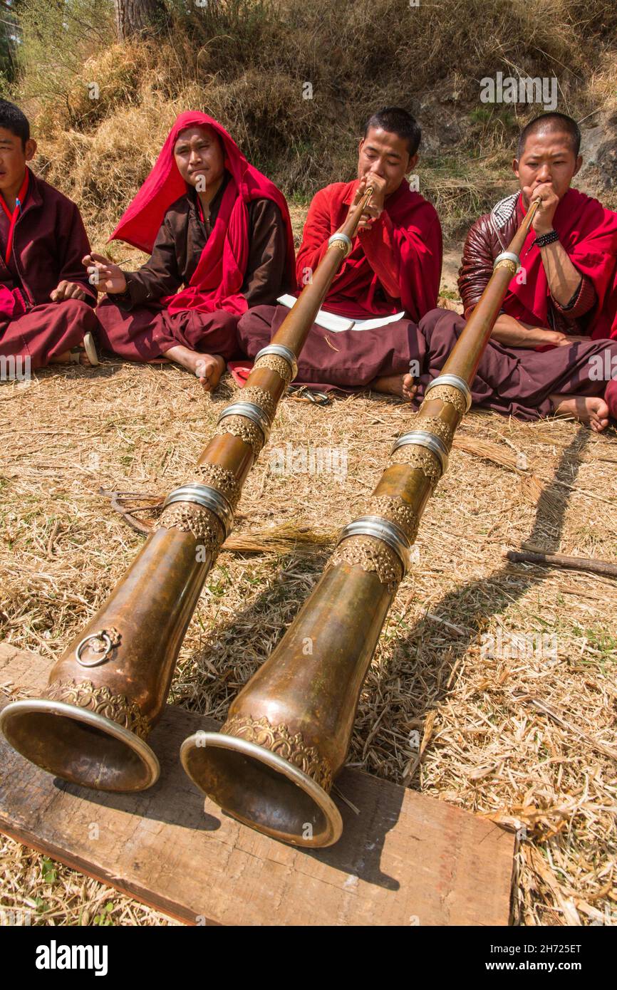 Young Buddhist monks practicing the Tibetan dungchen horn at the Dechen ...