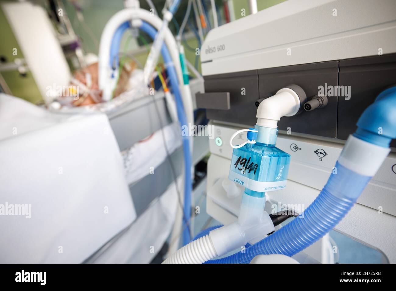 Gauting, Germany. 19th Nov, 2021. Ventilation tubes are seen in front of an intubated Corona patient in an intensive care room at the Asklepios Clinic. The blue box in the foreground is a bacteria and virus filter that cleans the patient's exhaled air. Credit: Matthias Balk/dpa/Alamy Live News Stock Photo