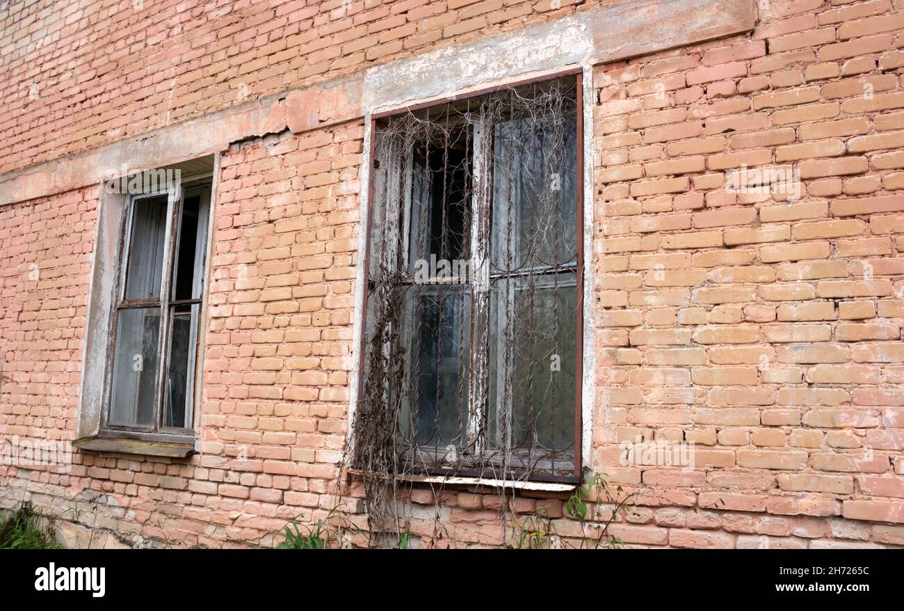Old windows with metal decorative bars in the old building. Old brick wall with windows Stock Photo