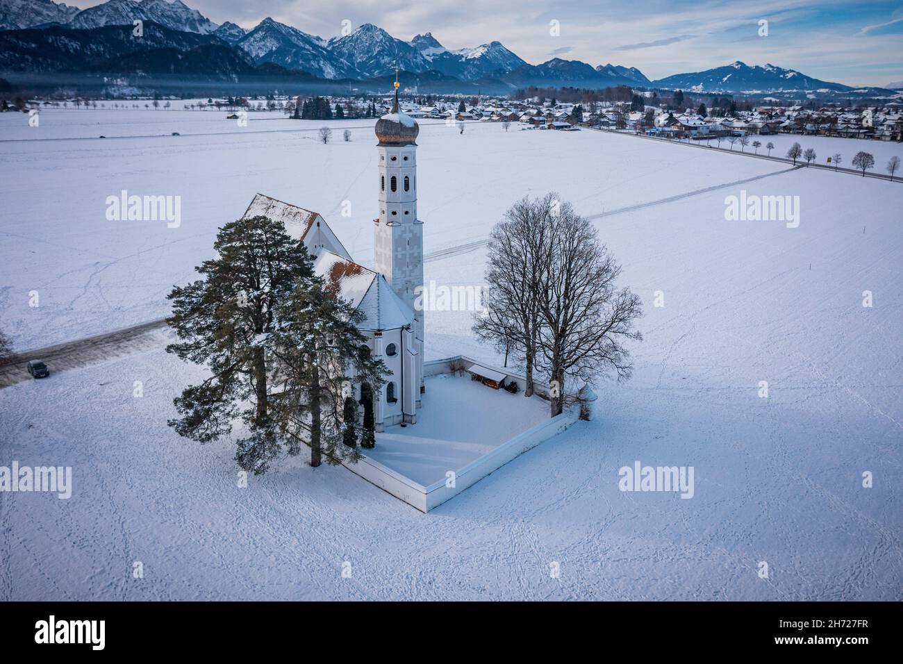 Scenic shot of the Saint Coloman church in Schwangu, Germany, surrounded by snowy mountains Stock Photo