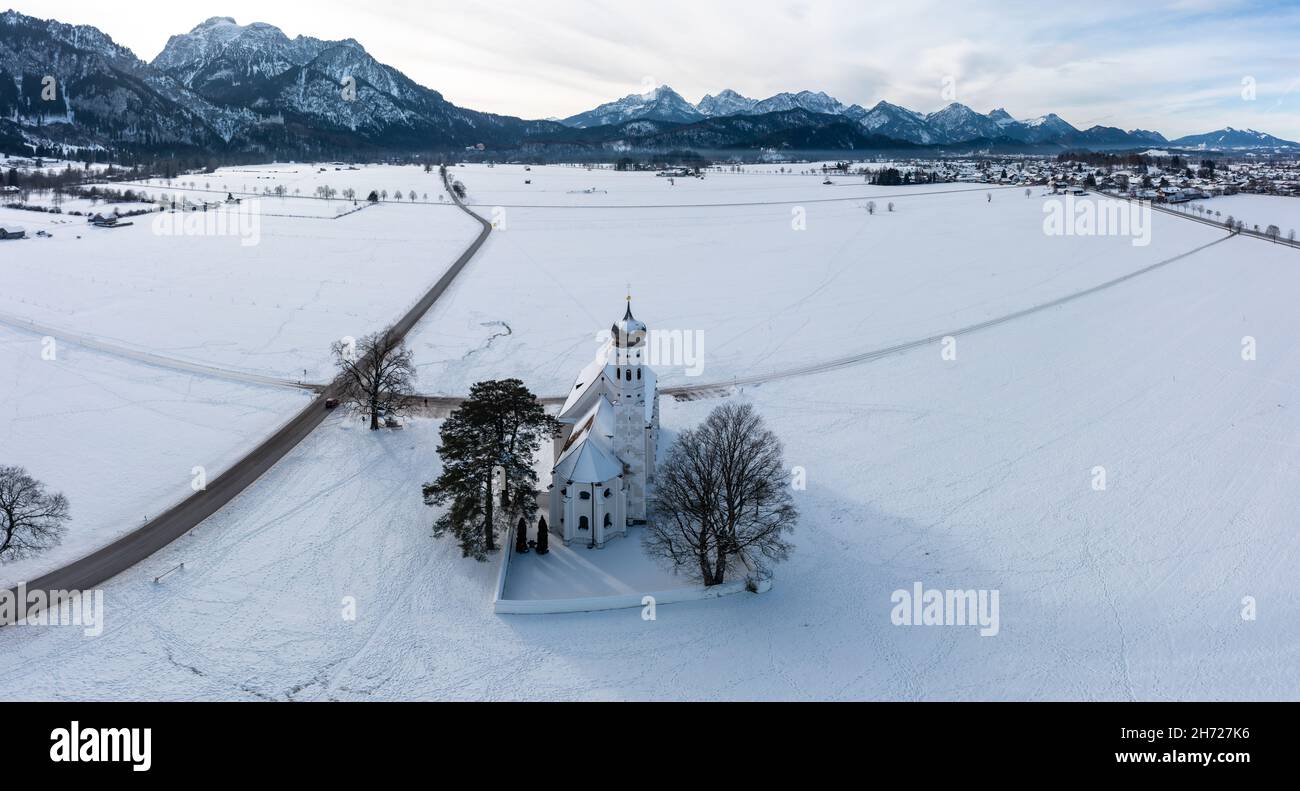 Scenic shot of the Saint Coloman church in Schwangu, Germany, surrounded by snowy mountains Stock Photo