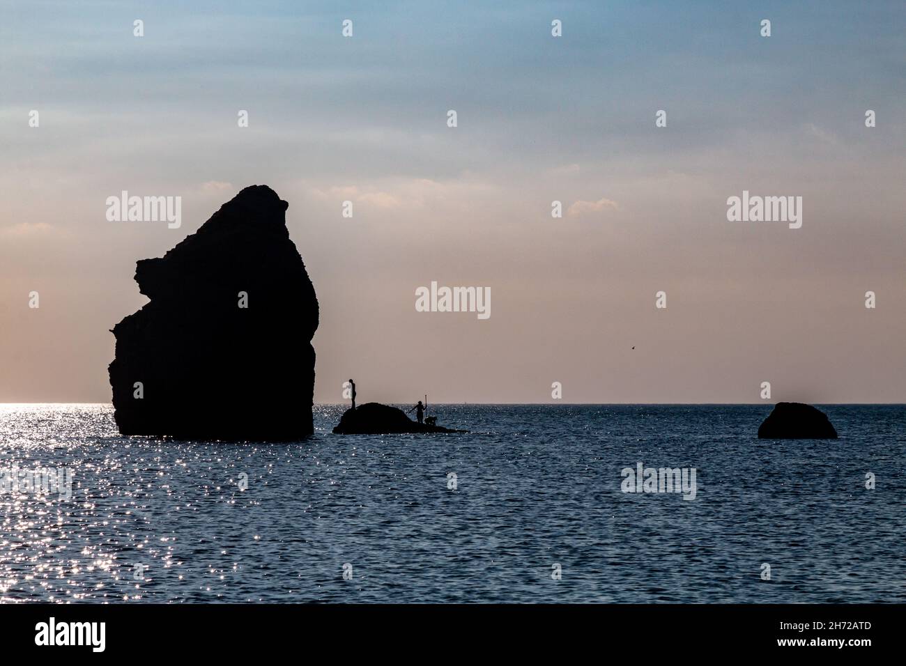 A view of the Thurlestone sihouetted in the early evening light from South Milton Sands beach, Devon, UK Stock Photo