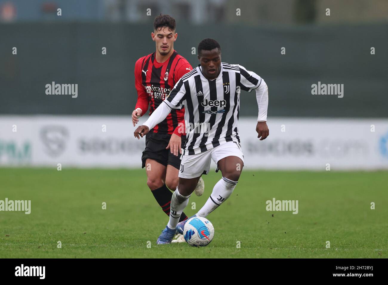 Milan, Italy, 19th November 2021. Ange Josue Chibozo of Juventus is pursued  by Andrea Capone of AC Milan during the Campionato Primavera match at  Centro Sportivo Vismara, Milan. Picture credit should read:
