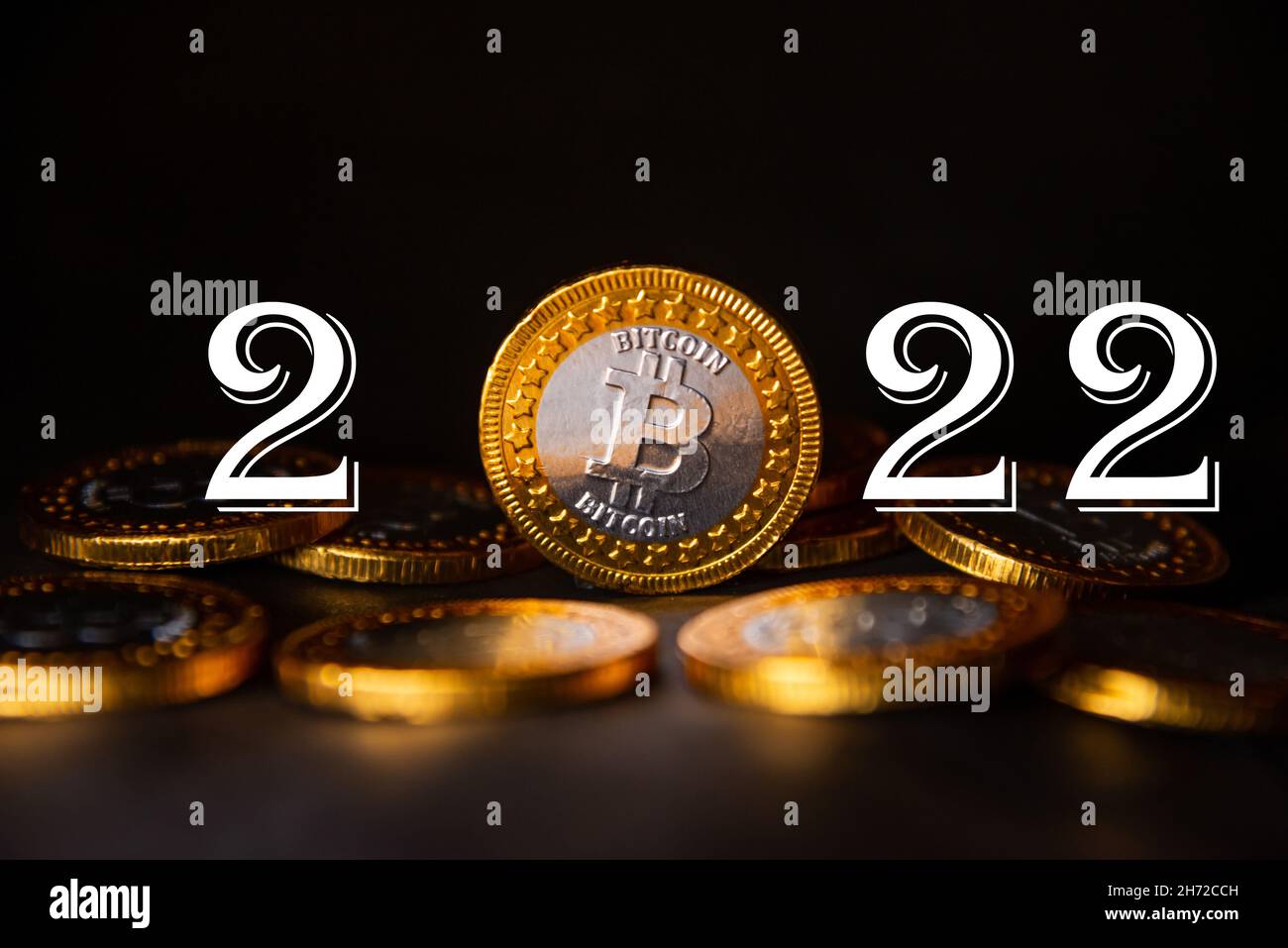 2022 year Cryptocurrency financial concept. Golden bitcoin and number 2022 on pile of coin. Copy space. Stock Photo