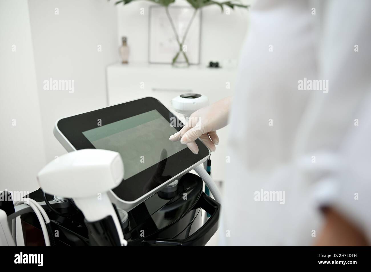 Beautician adjusting the apparatus for ultrasonic cavitation of the
