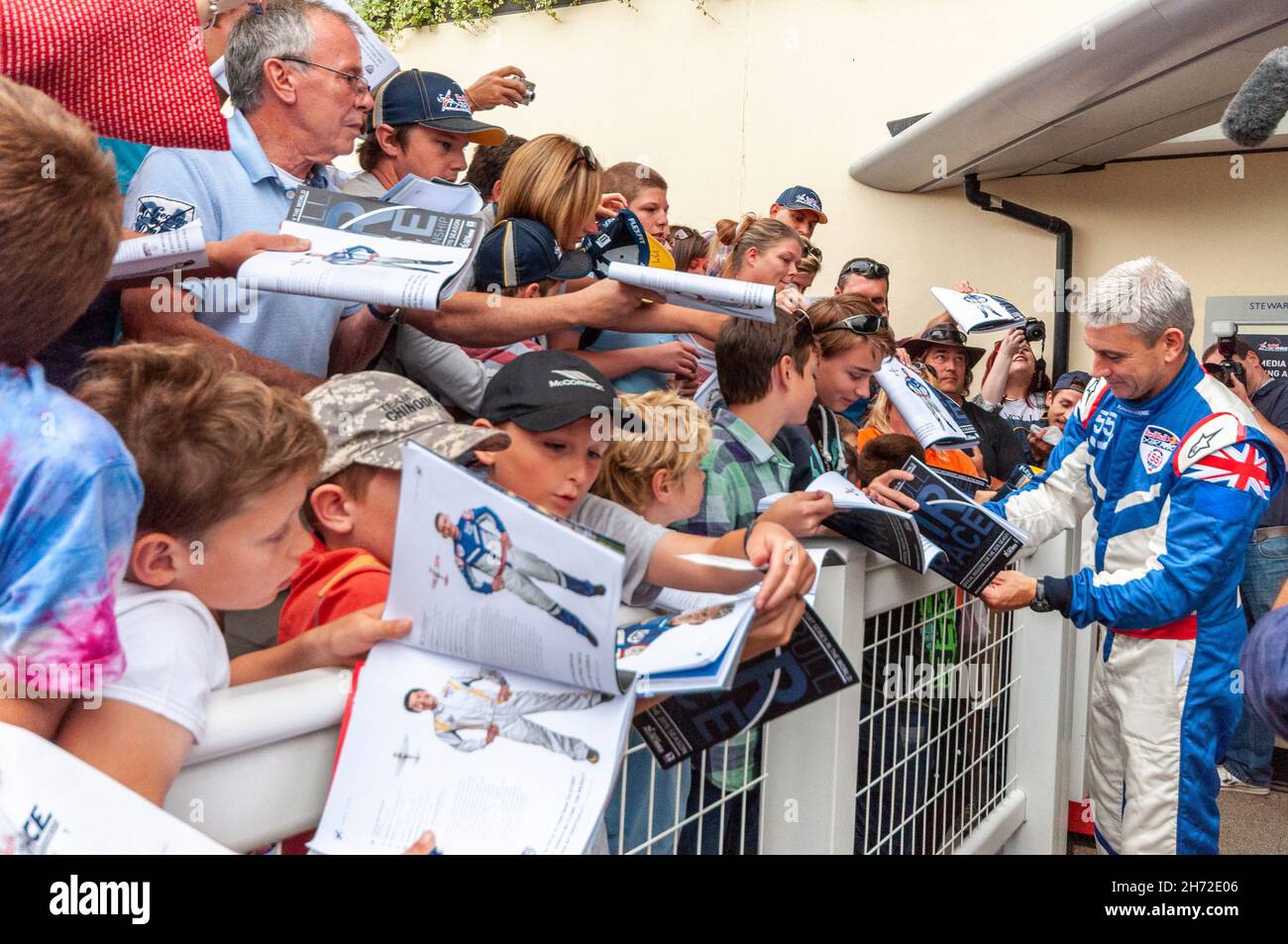 Winner Paul Bonhomme signing autographs after the Red Bull Air Race at Royal Ascot 2015. Autograph hunters. Autographing event programmes. Young fans Stock Photo
