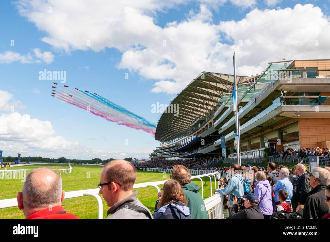 Royal Air Force Red Arrows display team flypast over the grandstand at Royal Ascot racecourse, Royal Berkshire, UK, during the Red Bull Air Race event Stock Photo