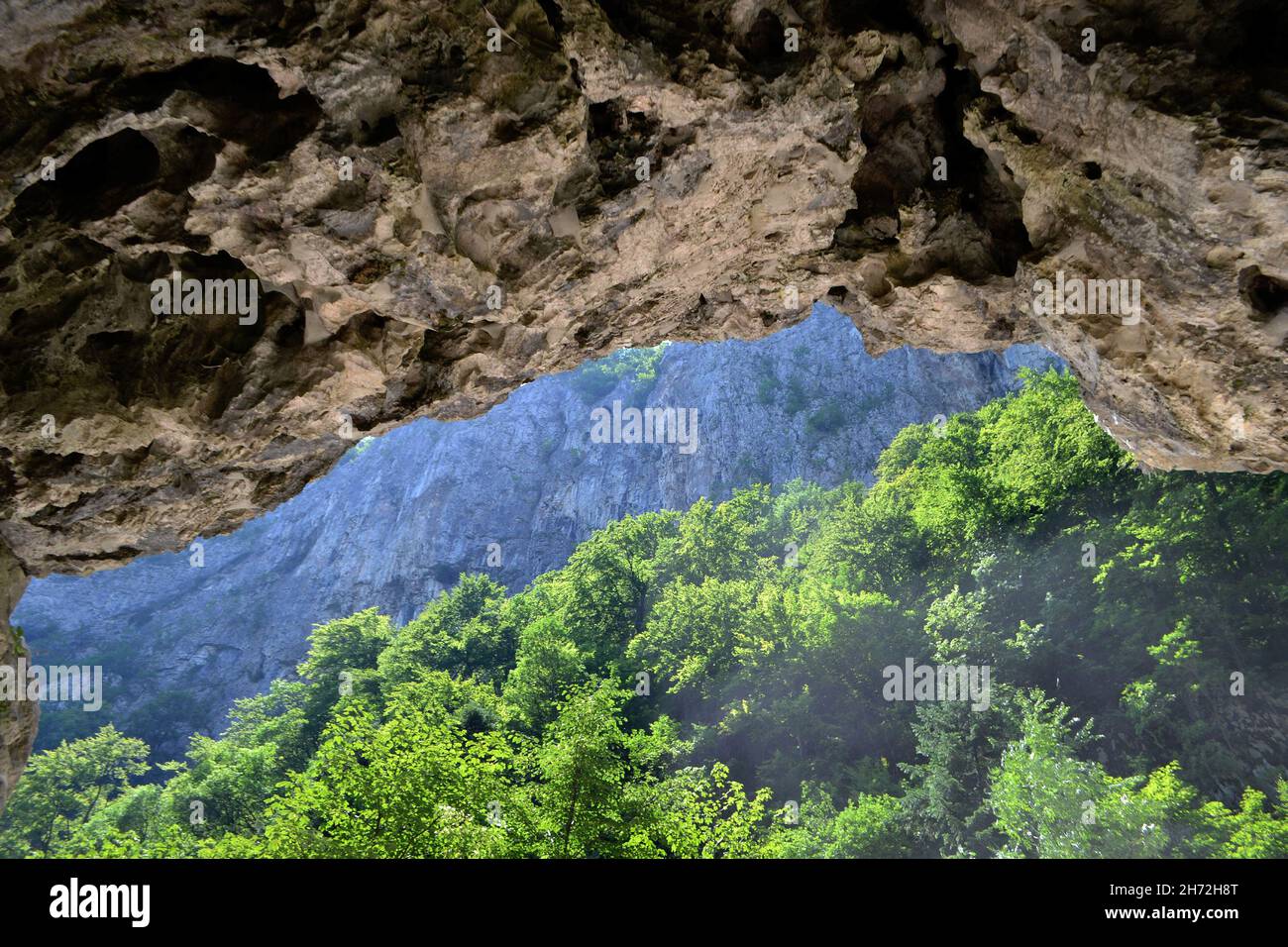 Entrance to the Polovragi cave from Cheile Oltetului Polovragi Cave is located in the Căpățânii Mountains, on the banks of the Olteț, Stock Photo