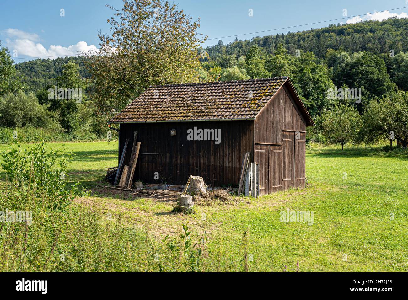 Wooden garden shed in the middle of a green meadow Stock Photo