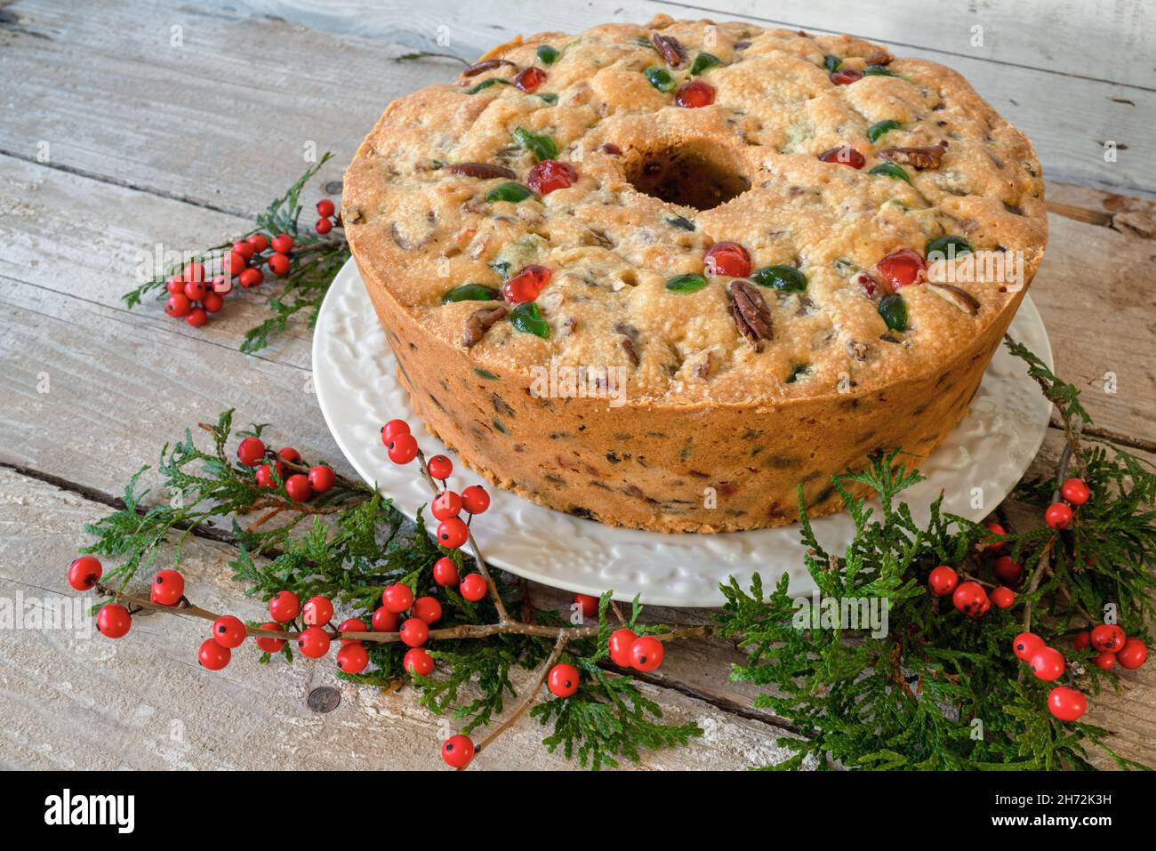 Traditional homemade fruitcake decorated with pecans and candied cherries. Stock Photo