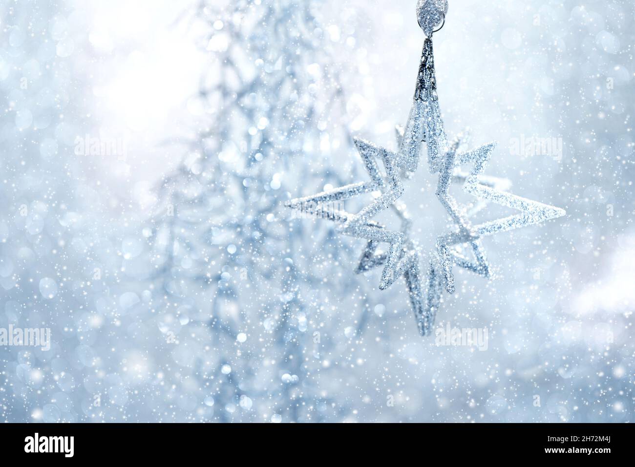 Christmas decoration with falling snow effect. Silver star blue light Stock Photo