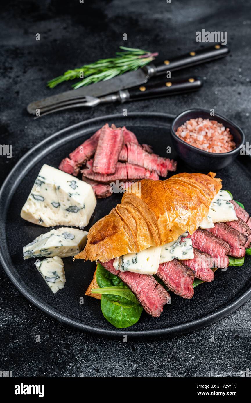 Sandwich with Fillet Mignon meat steak, Croissant and blue cheese. Black background. Top view