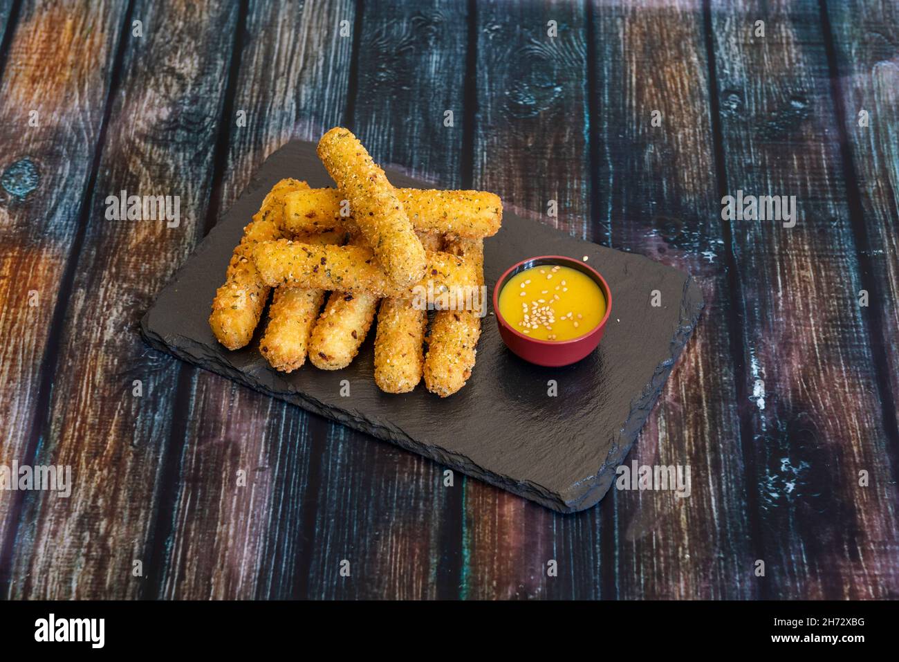 Mozzarella sticks are long pieces of mozzarella cheese that are battered or breaded and fried. Often served in restaurants as an aperitif Stock Photo