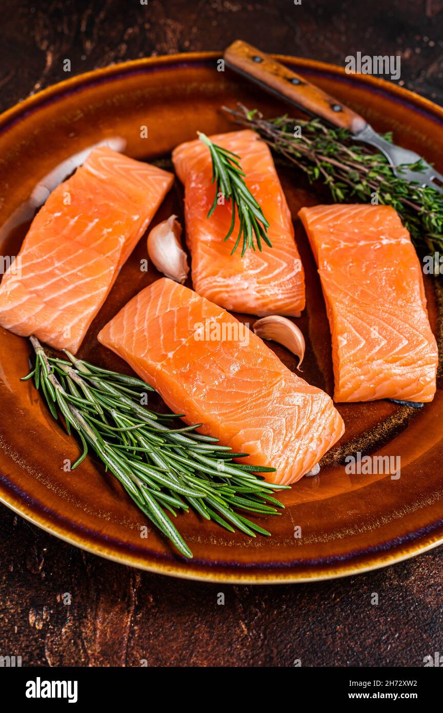 Fresh Raw salmon fish fillet steaks on rustic plate with thyme and ...