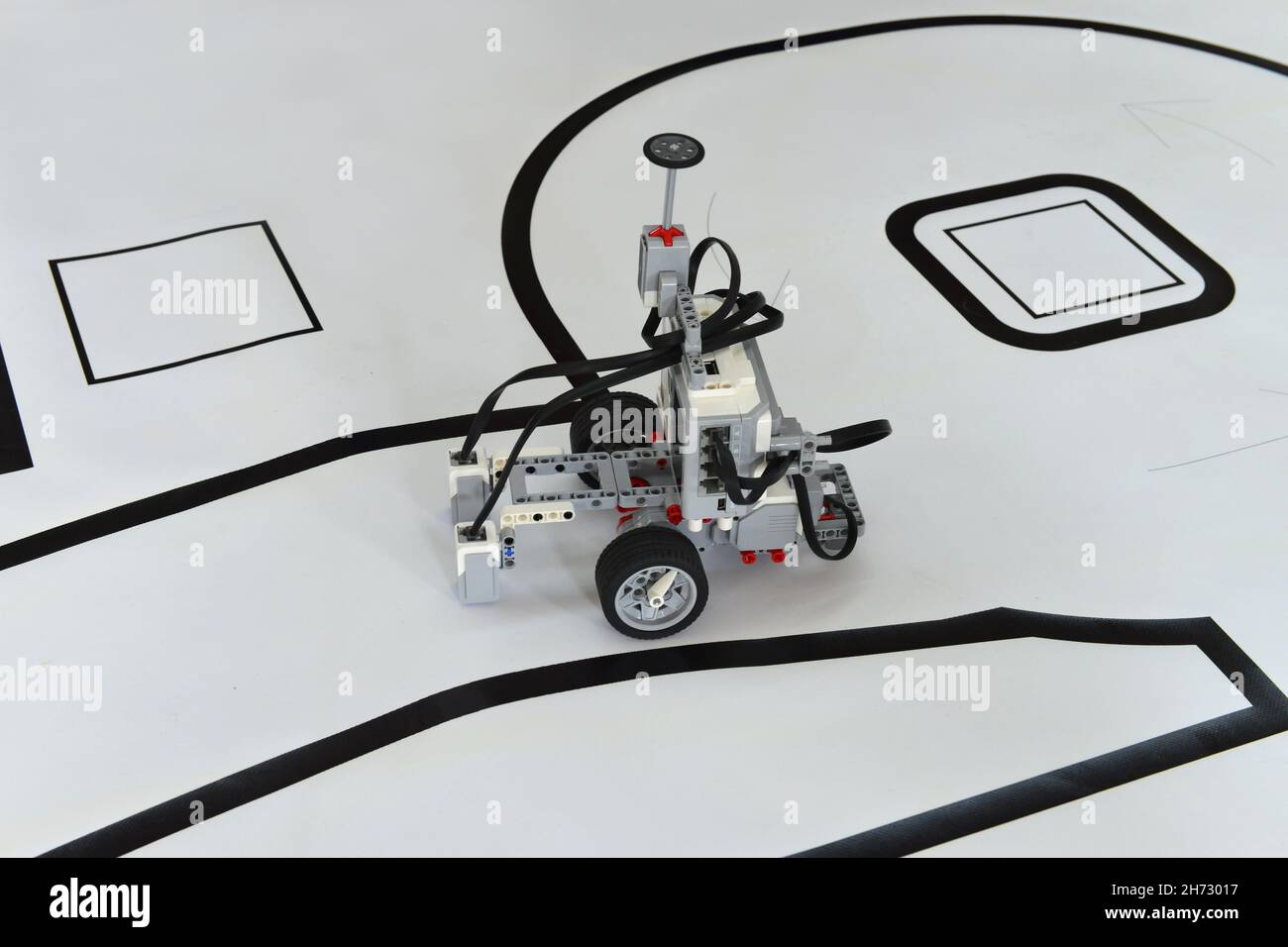 Programmable robot with wheels driving on paper road. robotic car with obstacle line follow ability Stock Photo