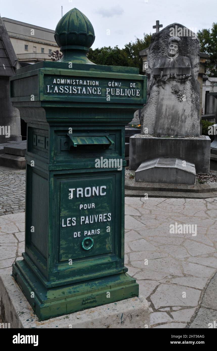 A cast-iron box for donations to help the poor stands on a path at the historic Passy Cemetery (Cimetière de Passy) in Paris. Stock Photo