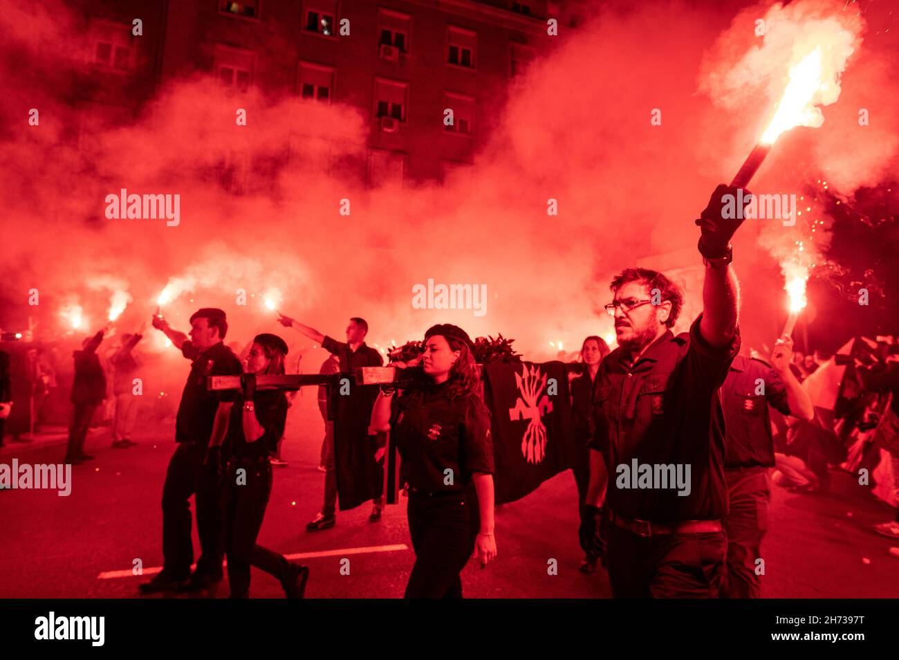 Madrid, Spain. 19th Nov, 2021. Far right wing members and supporters of La Falange carrying a crown with flares during a demonstration for the anniversary of the death of Jose Antonio Primo de Rivera, founder of La Falange, commemorating the 85th anniversary of his death on 20 November 1936, shot at the beginning of the Spanish Civil War. Credit: Marcos del Mazo/Alamy Live News Stock Photo