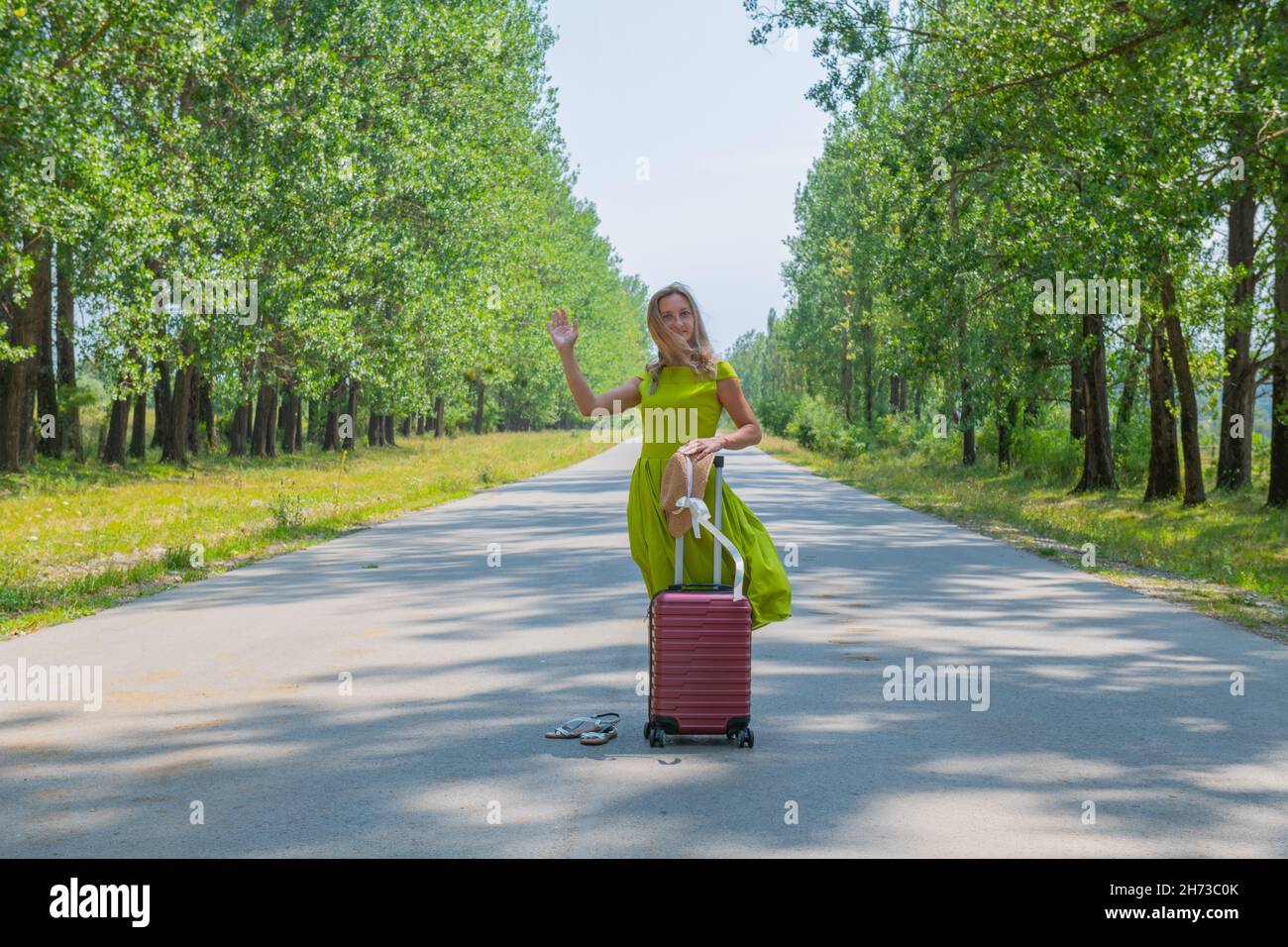 a girl in a green dress stands on the road Stock Photo - Alamy